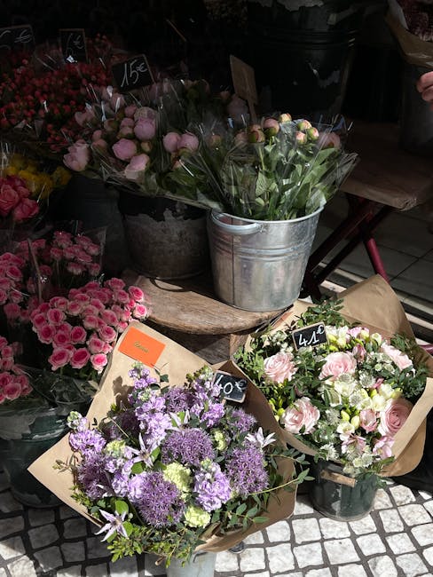 A display of fresh floral arrangements and bouquets at Chadwell Heath florist, featuring a variety of flowers including pink roses, purple lavender, and white blooms. The flowers are arranged in rusti
